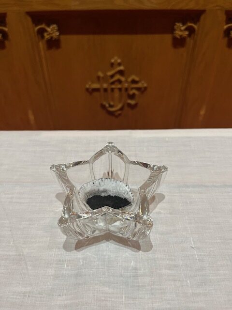 glass star shaped bowl with ashes on fair linen